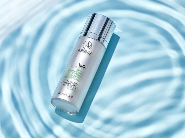 Bottle of Aprive Tao REPAIR cream for dry, irritated skin floating on blue rippling water, representing summer skincare.