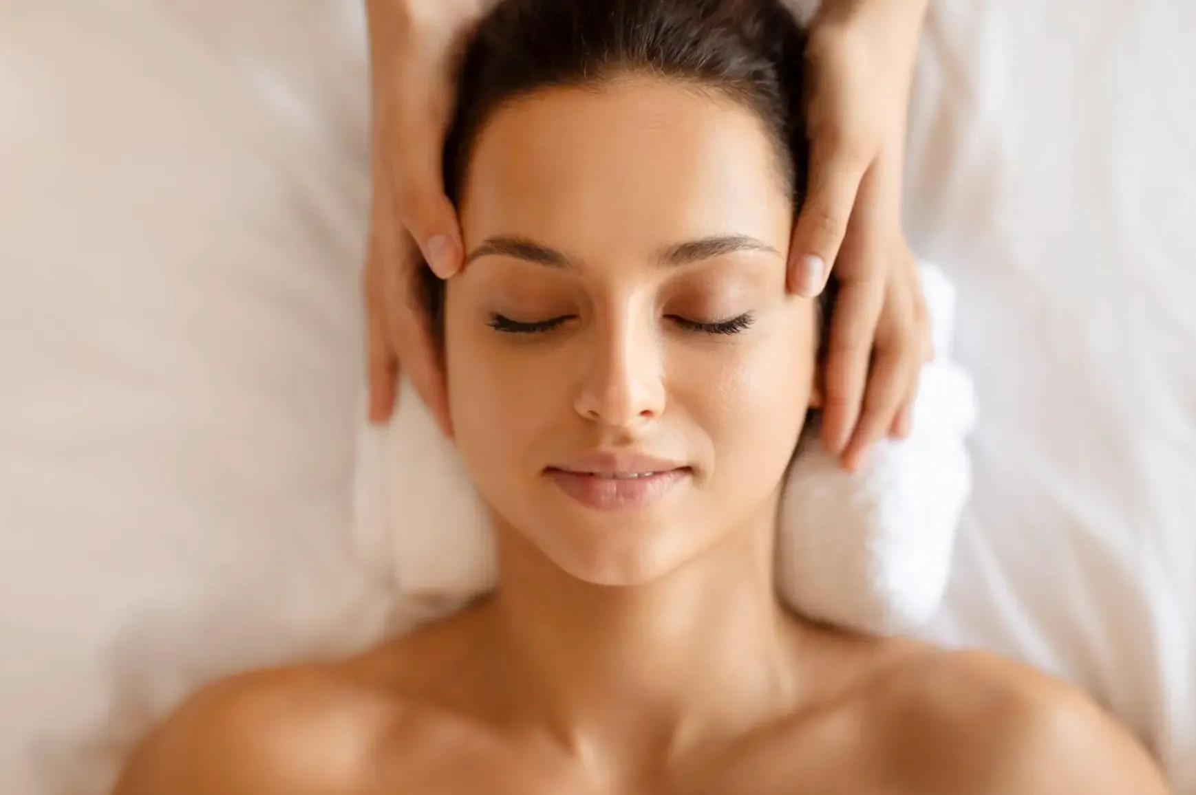 Woman receiving a soothing facial massage to revitalize skin.