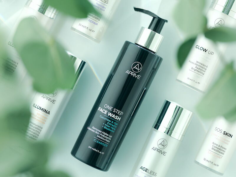 Assortment of APRIVE natural and organic skincare bottles with green leaves.