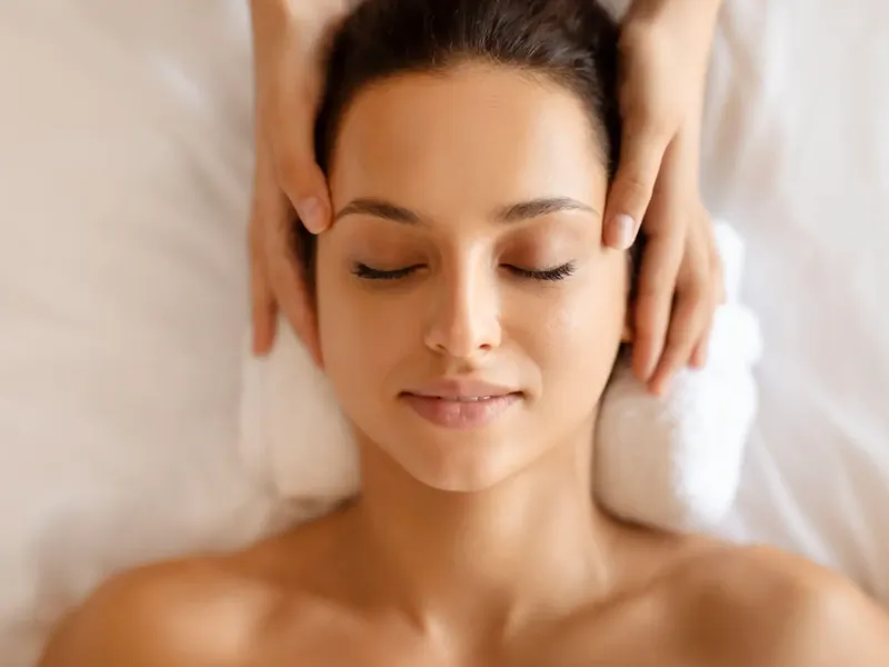 Woman receiving a soothing facial massage to revitalize skin.