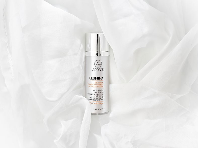 Bottle of APRIVE ILLUMINA BB cream in shade 01 nude beige nestled in soft white fabric.